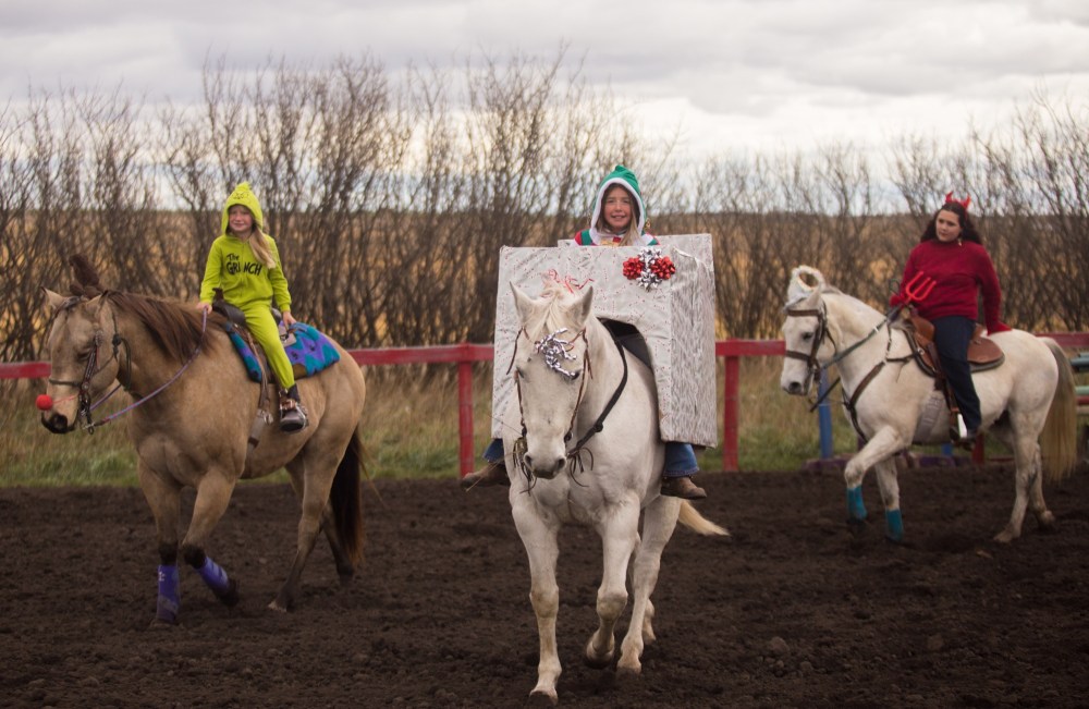 Emerson Beernaerts, 8, left, Easton Beernaerts, 10, and Natalie Elias, 14, ride in the costume contest at the Lucky Break Ranch Halloween Jackpot Race Sunday. (Chelsea Kemp/The Brandon Sun)