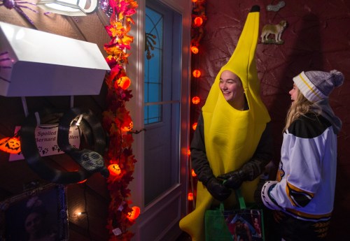 Clair Slomiany, 13, left, and Shayla Scinocca, 13, wait for candy Sunday at a house of Rosser Avenue. (Chelsea Kemp/The Brandon Sun)