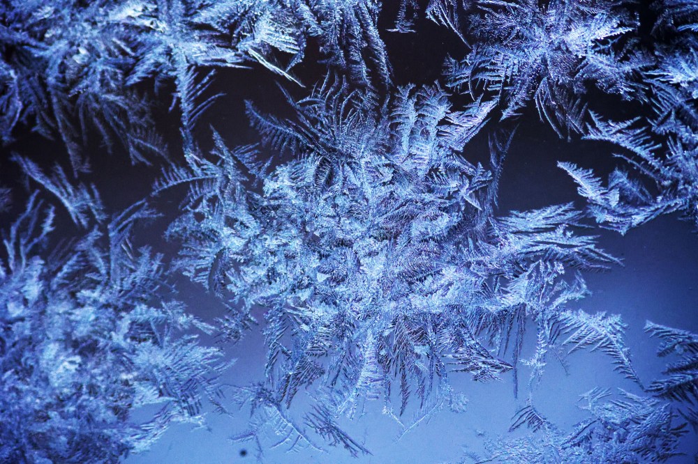 Patterns of frost that formed on my porch windows overnight on Monday are seen here against the light from the house next door. (Matt Goerzen/The Brandon Sun)