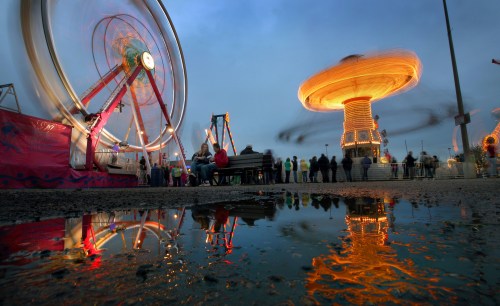 Bruce Bumstead/Brandon Sun
A timed-exposure captures the twirling motion of the midway rides, which were reflected in a puddle, at the Manitoba Summer Fair.