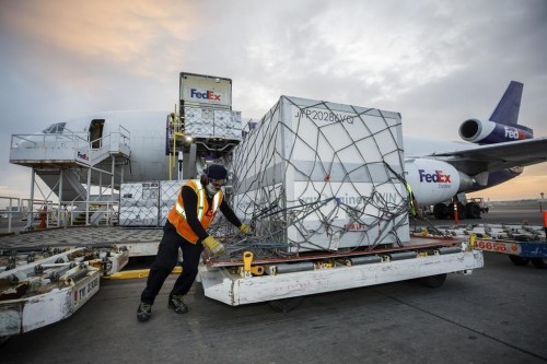 Workers unload a shipment of the Moderna COVID‑19 vaccine at the FedEx hub at Pearson International Airport in Toronto on May 20, 2021. Canada's auditor general is expected to release two highly anticipated reports on the government's handling of the COVID-19 crisis in 2021, including access to vaccines and pandemic benefits. THE CANADIAN PRESS/Cole Burston