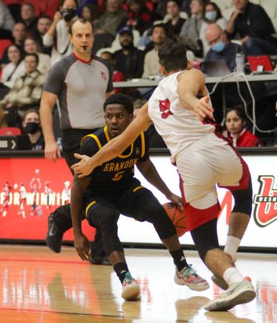 Brandon guard Khari Ojeda-Harvey dribbles against Winnipeg guard Alberto Gordo during the Wesmen Classic men’s basketball tournament semifinals at the Duckworth Centre on Thursday. (Thomas Friesen/The Brandon Sun)