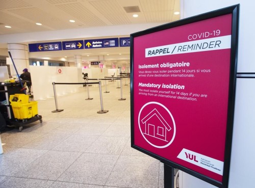 A sign reminds arriving passengers to quarantine against COVID-19 at Trudeau Airport in Montreal, Friday, Feb. 19, 2021.  THE CANADIAN PRESS/Ryan Remiorz