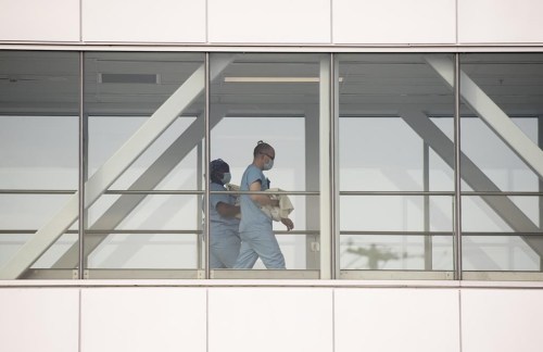 Health-care workers walk across a sky bridge at a hospital in Montreal, Sunday, Feb. 6, 2022. Researchers who study responsible artificial intelligence say a Montreal hospital network's plan to use AI to reduce emergency room wait times is an appropriate use of the technology, if it’s done carefully. THE CANADIAN PRESS/Graham Hughes