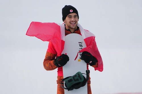 World Cup snowboard cross in Mont-Sainte-Anne, Que., has been postponed because of warm temperatures and lack of snow. Canada's Eliot Grondin celebrates his silver medal in men's snowboard cross at the 2022 Beijing Winter Olympics in Zhangjiakou, China on Thursday, February 10, 2022. THE CANADIAN PRESS/Sean Kilpatrick