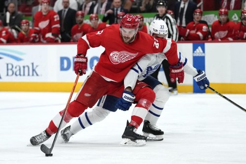 Detroit Red Wings center Michael Rasmussen (27) protects the puck from Toronto Maple Leafs defenseman Timothy Liljegren (37) in the second period of an NHL hockey game Thursday, Jan. 12, 2023, in Detroit. (AP Photo/Paul Sancya)