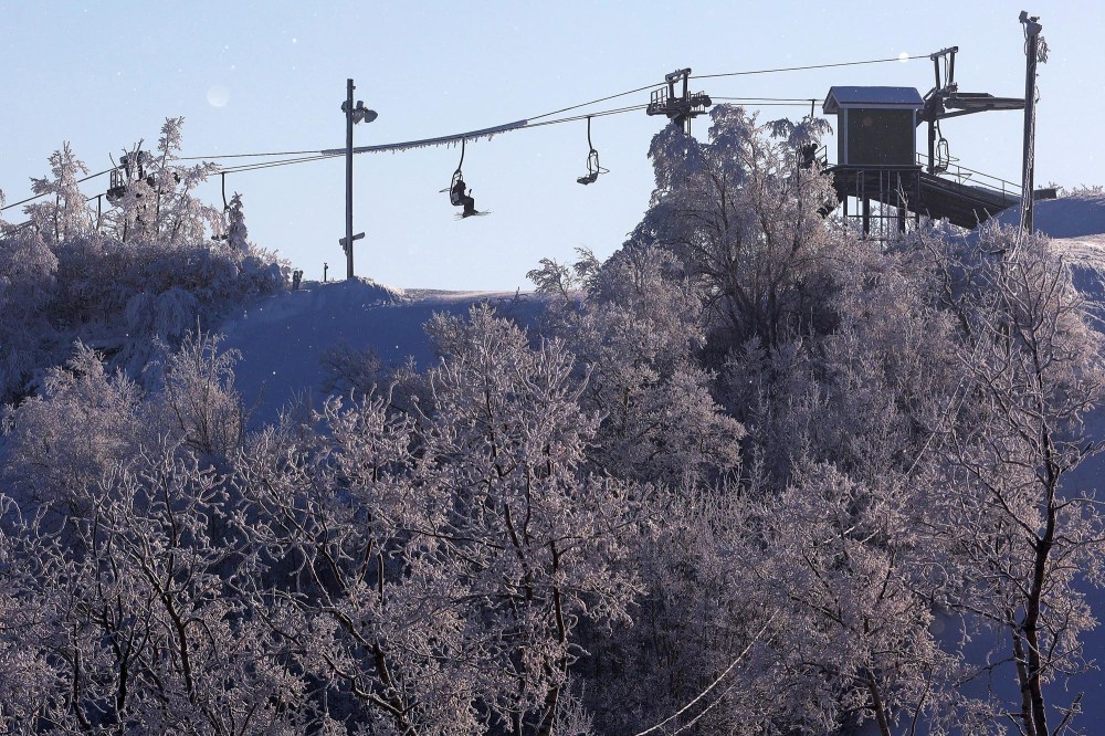 Skiers and snowboarders ride a chairlift, framed by hoar frost, during a crisp day of winter activities at Asessippi Ski Resort earlier this month. (Tim Smith/The Brandon Sun)