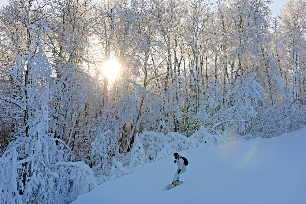 A snowboarder makes their way down a run as the sun shines through hoar frost covered trees at Asessippi Ski Resort on a sunny day in early January. (Tim Smith/The Brandon Sun)