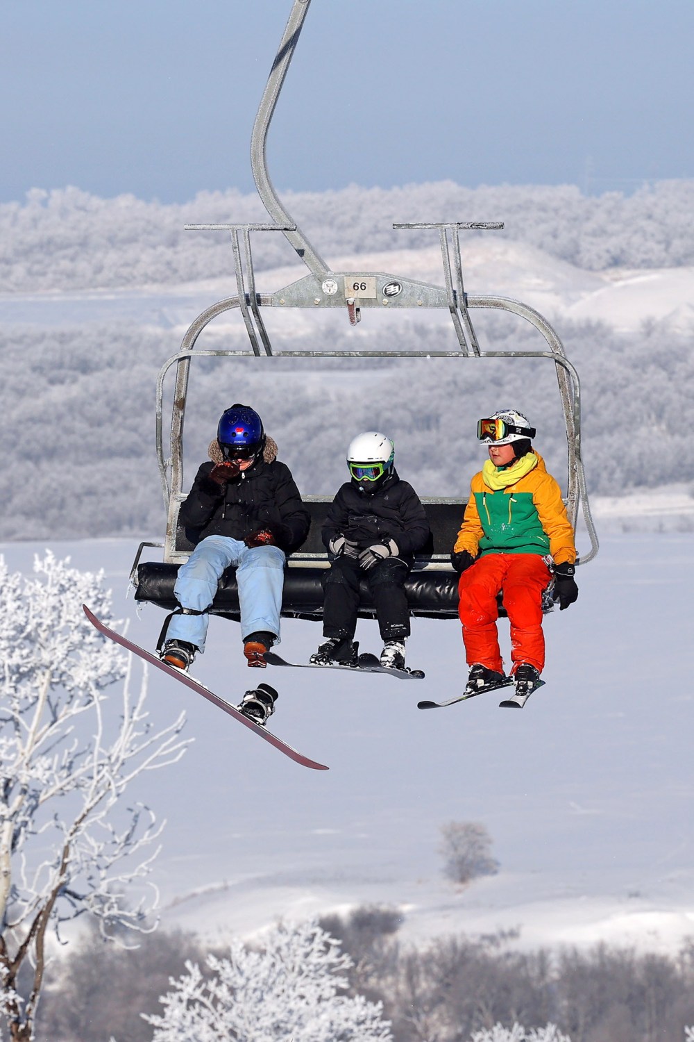 Skiers and snowboarders ride a chairlift, framed by hoar frost, during a crisp day of winter activities at Asessippi Ski Resort on a sunny day in early January. (Tim Smith/The Brandon Sun)